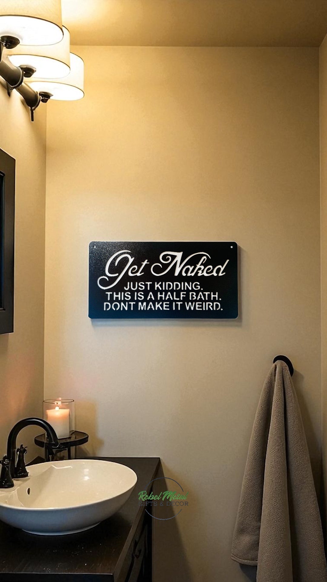 Black metal bathroom sign that says "Get naked" Just kidding. This is a half bath. Don't make it weird."