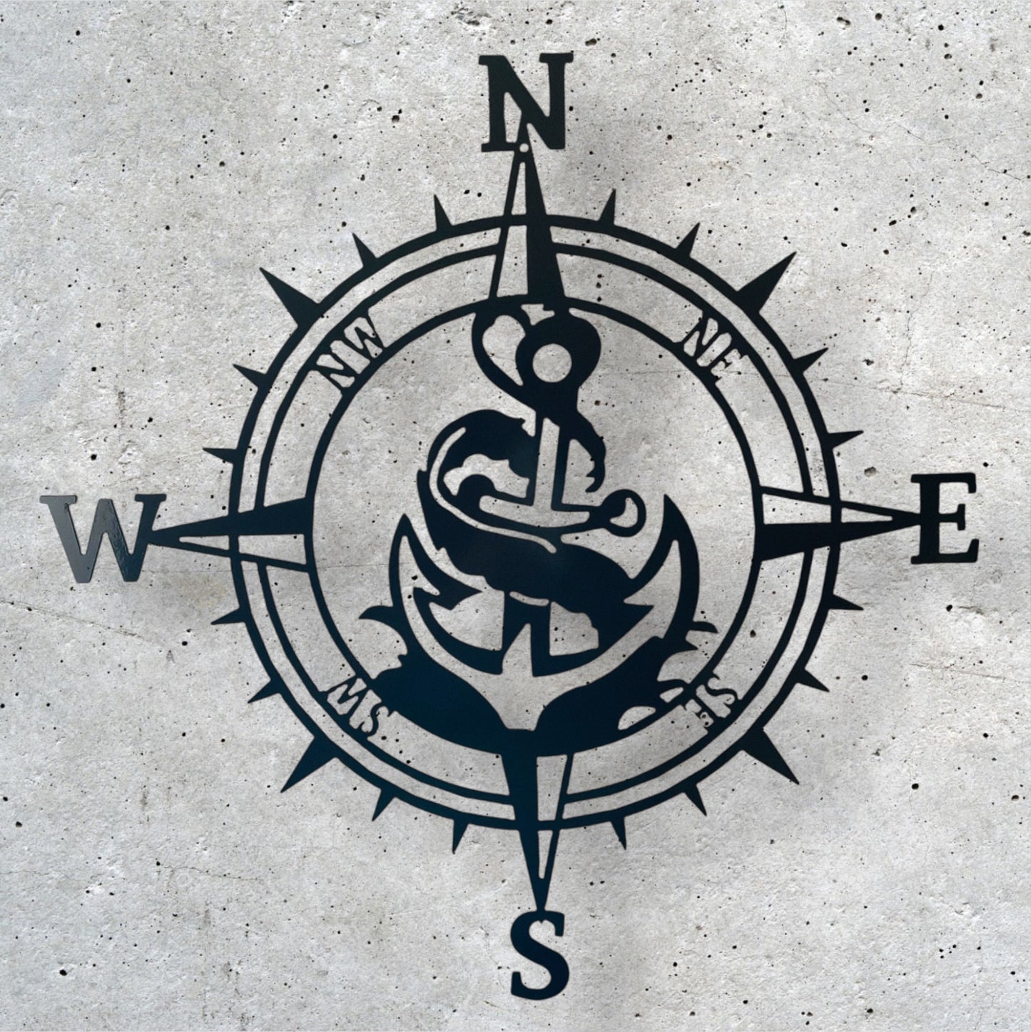 Navy blue compass with anchor design on a textured gray background