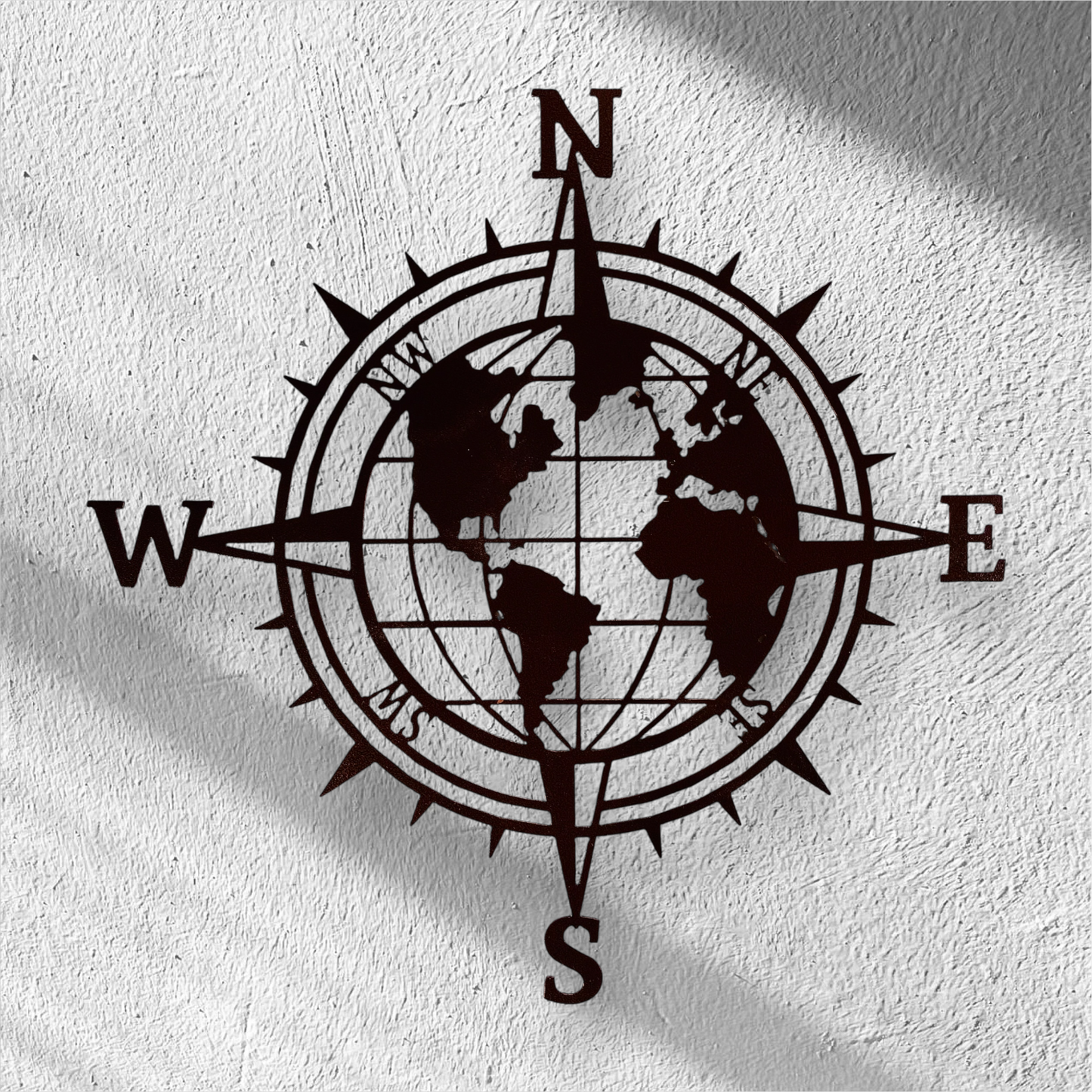 Black compass wall decoration with world map on a white wall
