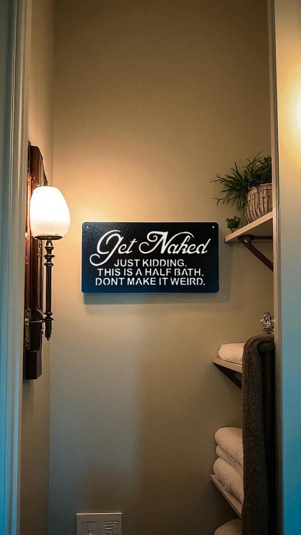 Bathroom sign on a wall that says...Get Naked. Just Kidding. This is a Half Bath. Don't make it weird with towels and a light fixture visible.