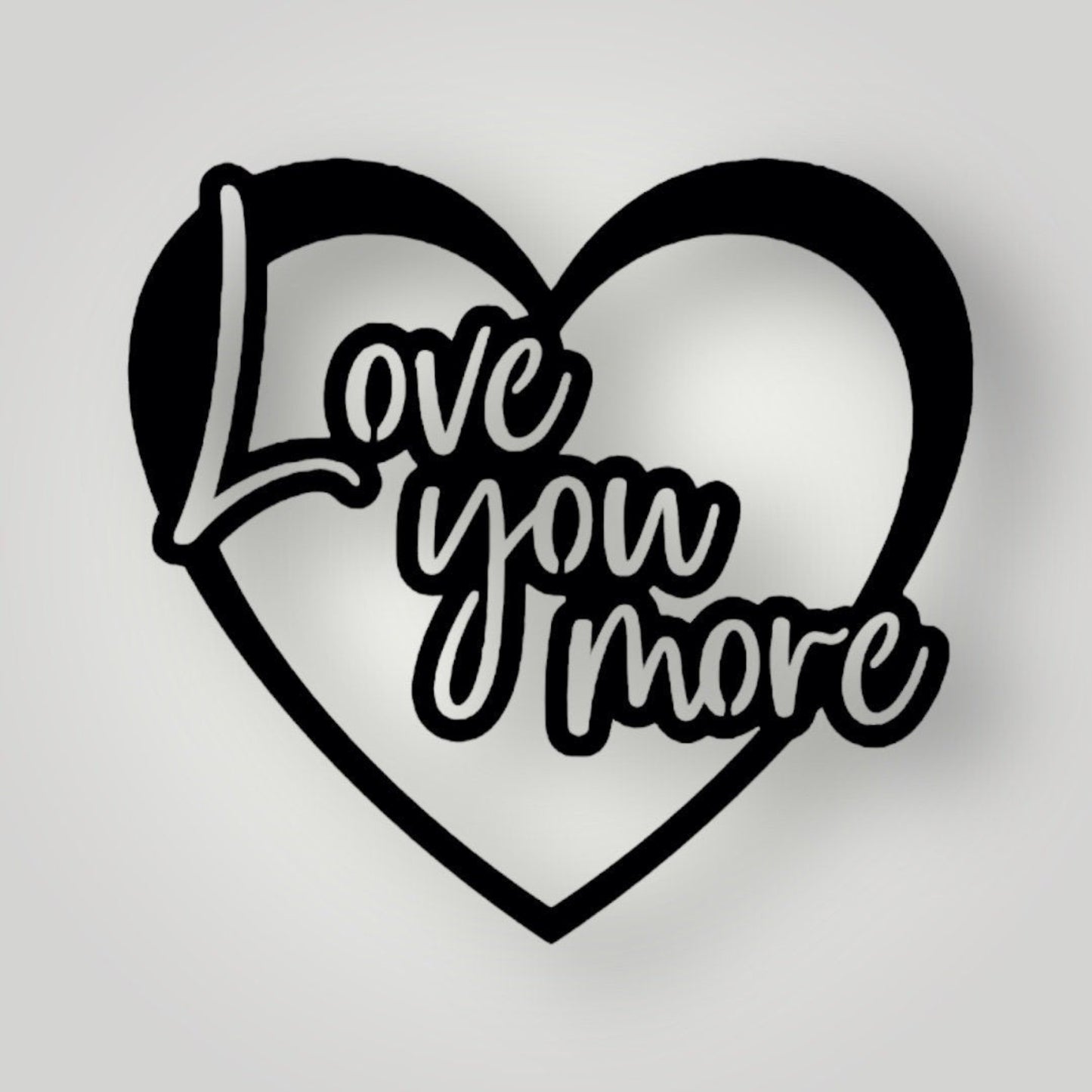 Metal wall sign colored black and says "Love you more"