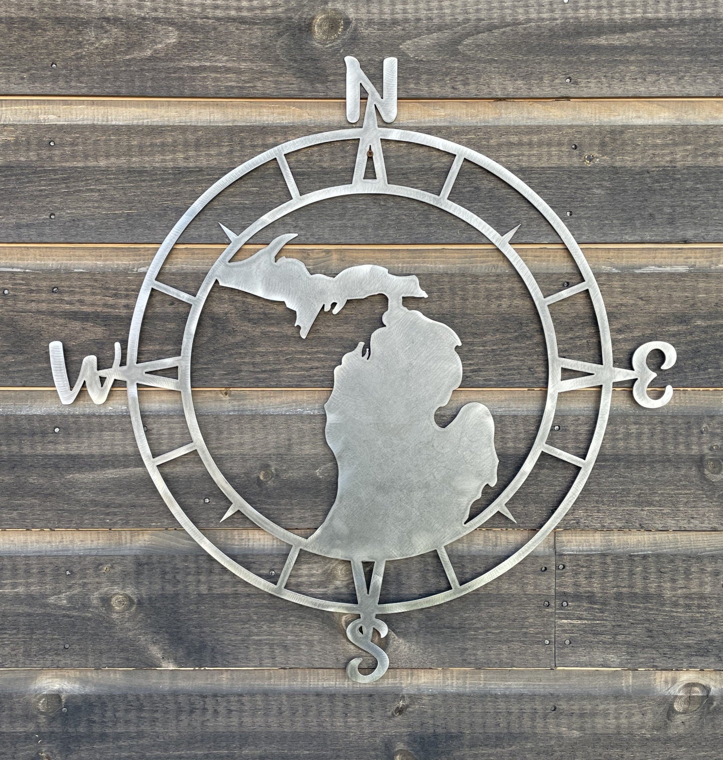 Metal compas wall decor with a silhouette of Michigan in the middle. Bare metal finish. all states available