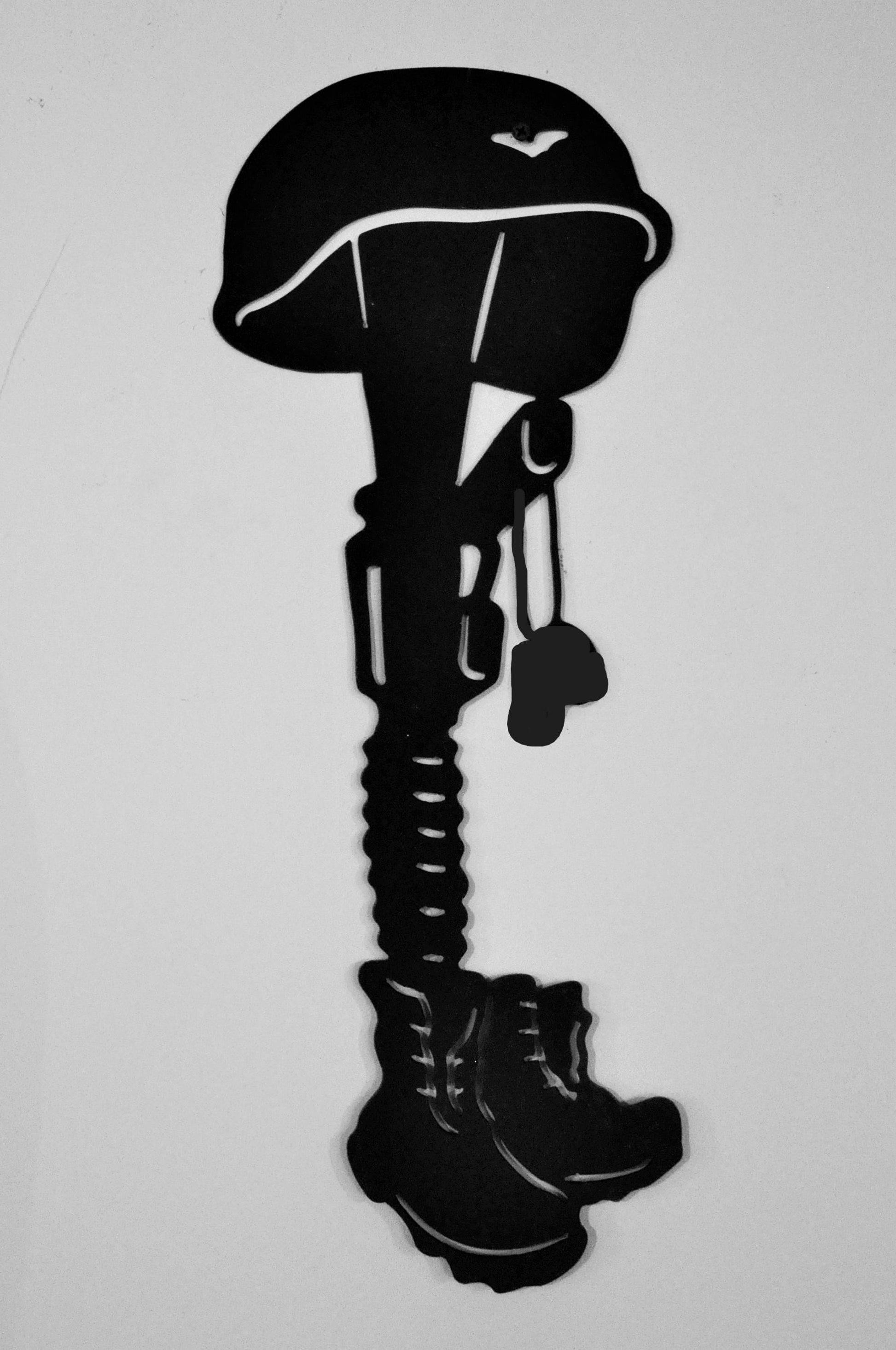 Fallen soldier memorial.  Boots, helmet, dog tags, and rifle metal art with ground stakes