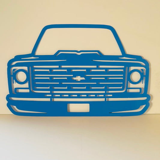 Blue metal cutout of a Chevy Truck showing front grille.o