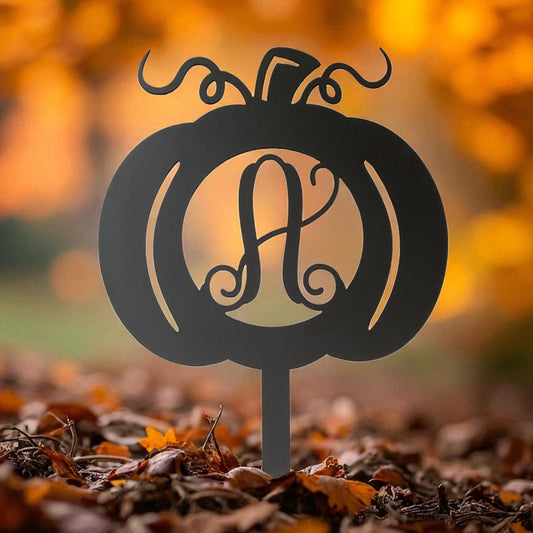 Black pumpkin-shaped monogram with 'A' on a stand against an autumn background