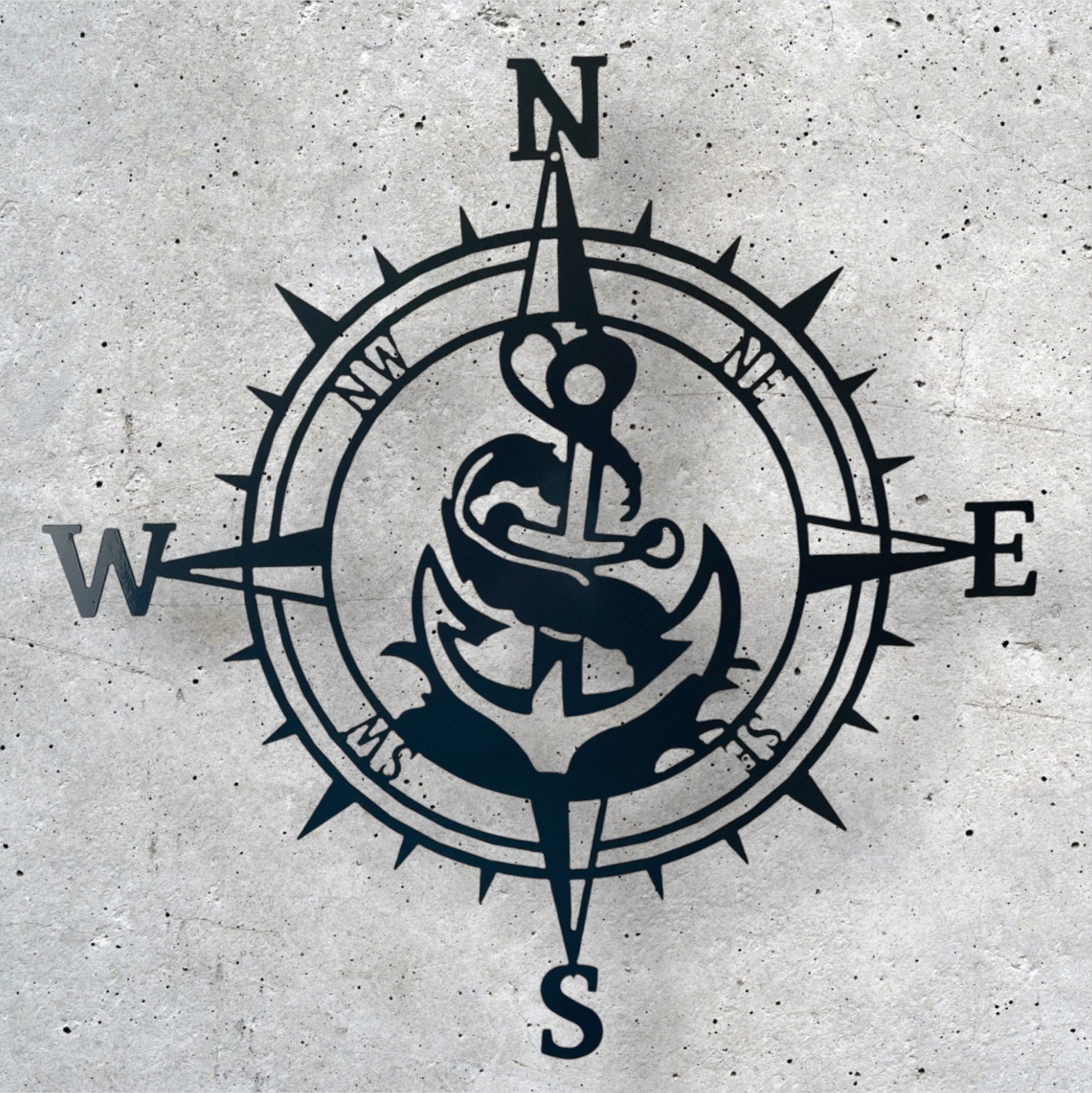 Navy blue compass with anchor design on a textured gray background