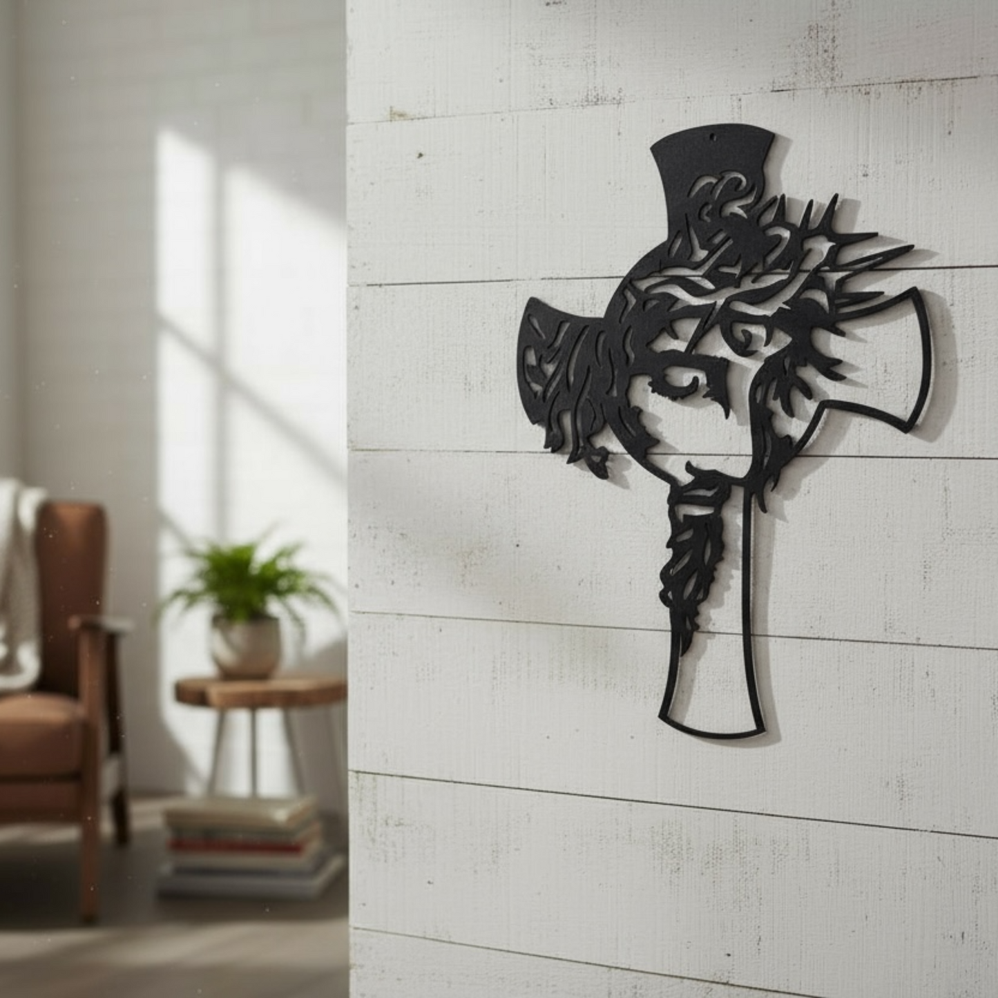 Decorative wall art of the face of Jesus within a cross on a white wall in a room with a chair and plant.