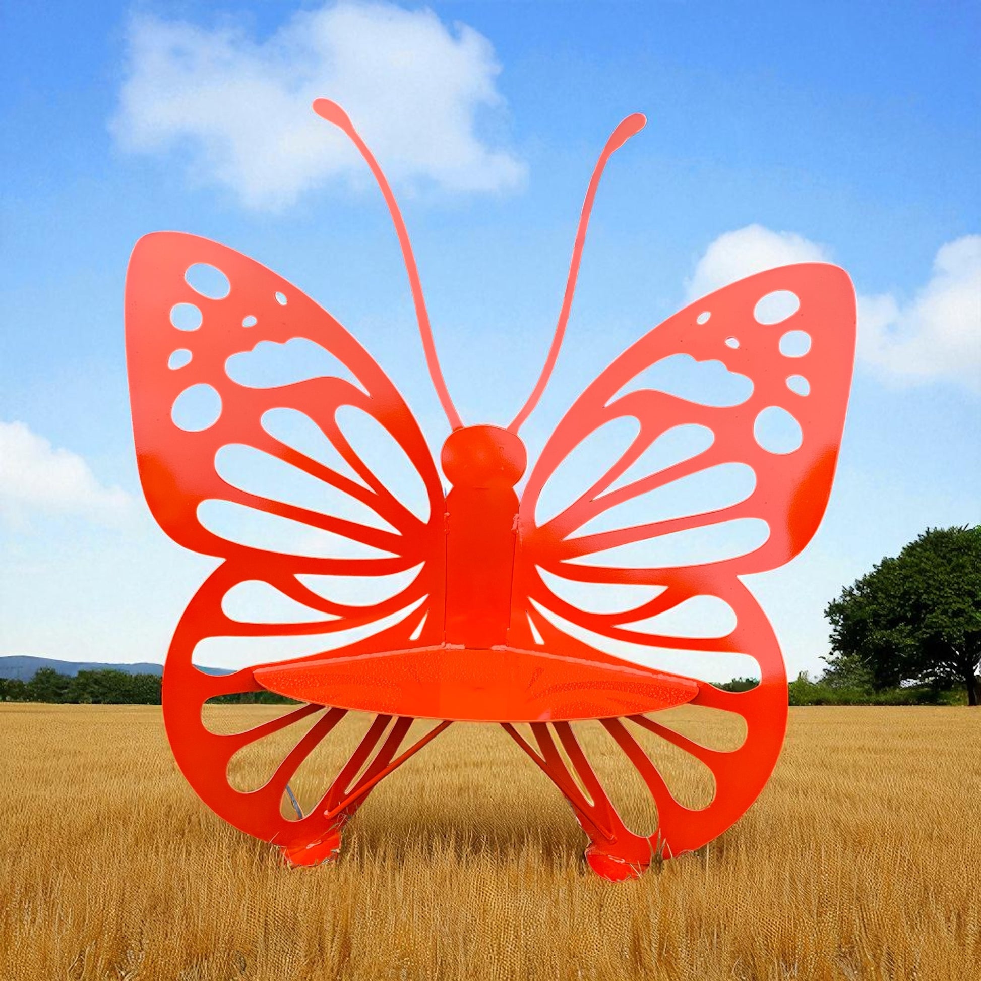 Orange butterfly-shaped bench in a field with a blue sky