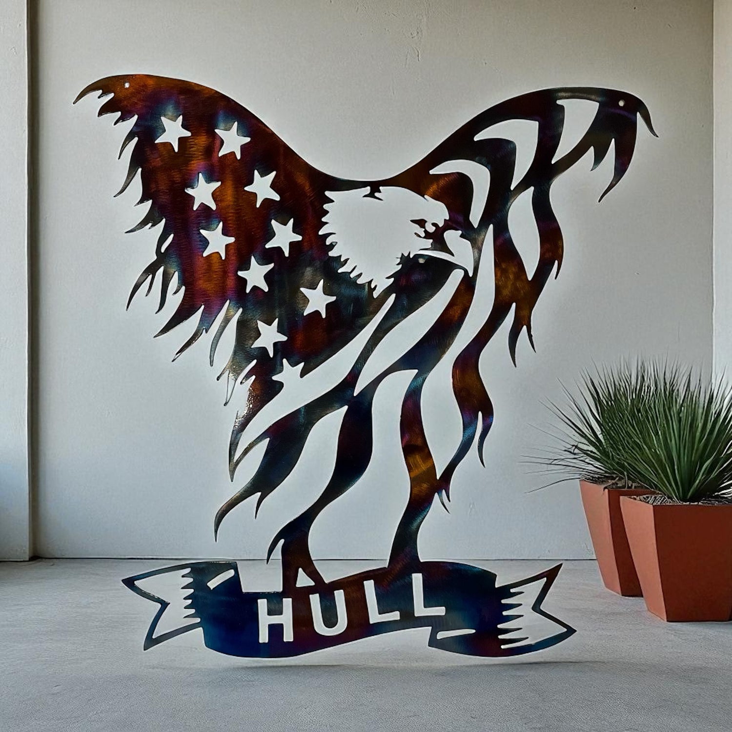 Metal wall art of an eagle with an American flag design and 'HULL' below, on a plain background.