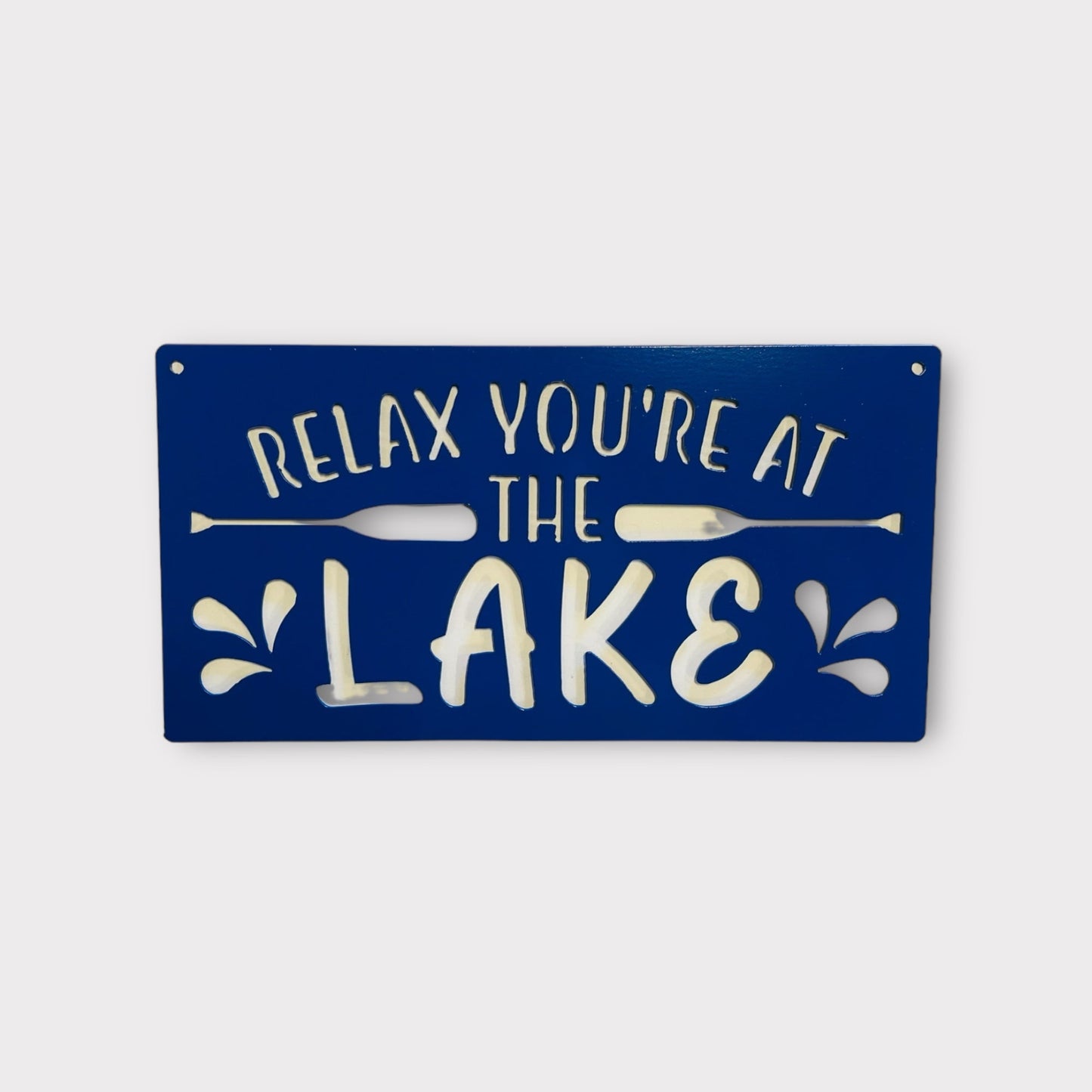 Rectangular metal sign with Relax You're at the Lake cut through. 