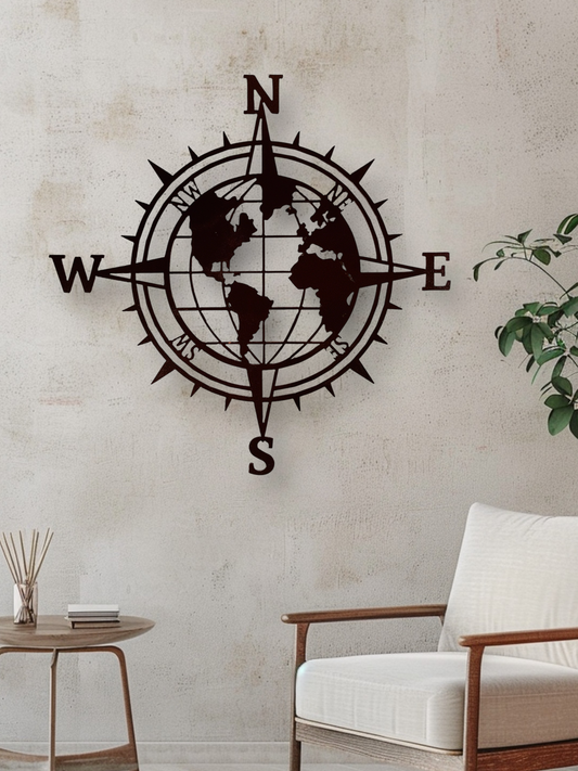 Decorative wall compass with world map design on a light-colored wall.