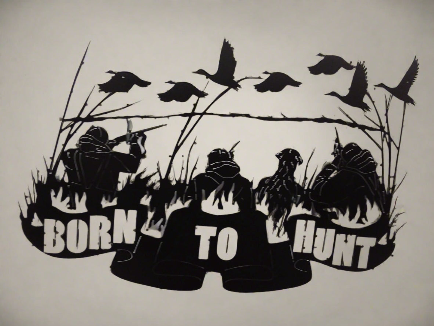 Metal art that says "Born to Hunt" with hunters a dog and geese.