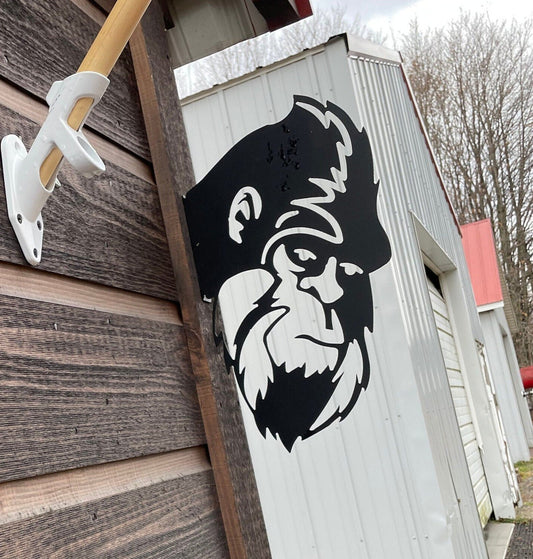 Metal cutout of Sasquatches head peeking around the corner garden art