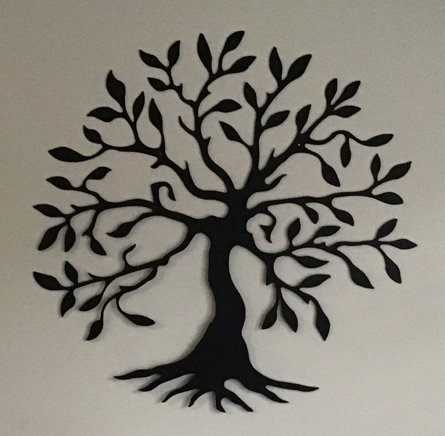Black metal wall art representing the olive tree