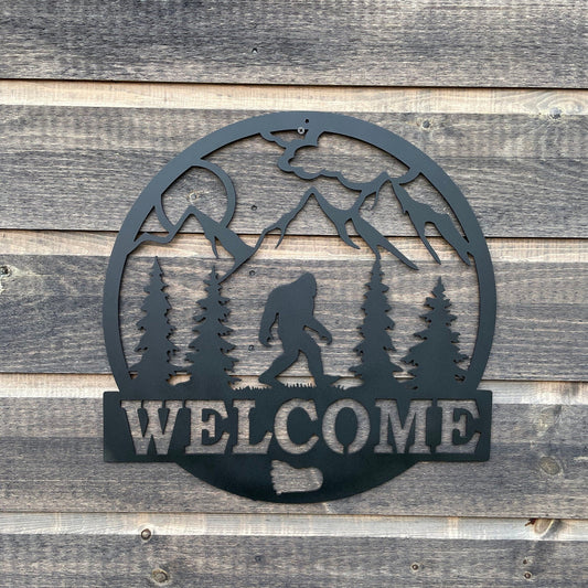 Bigfoot welcome sign with trees, mountains and sunshine