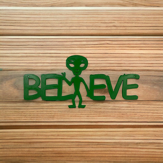 Alien metal sign that reads "Believe" with the i replaced with a little green alien