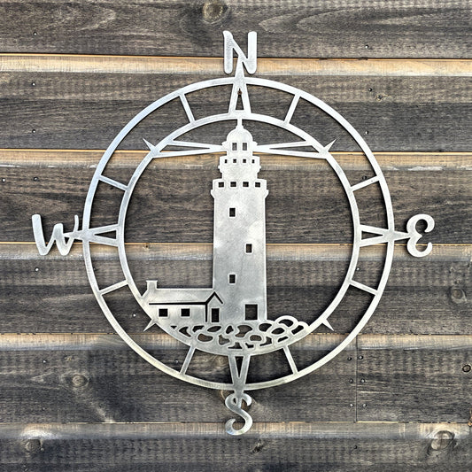 bare metal compass with a lighthouse scene