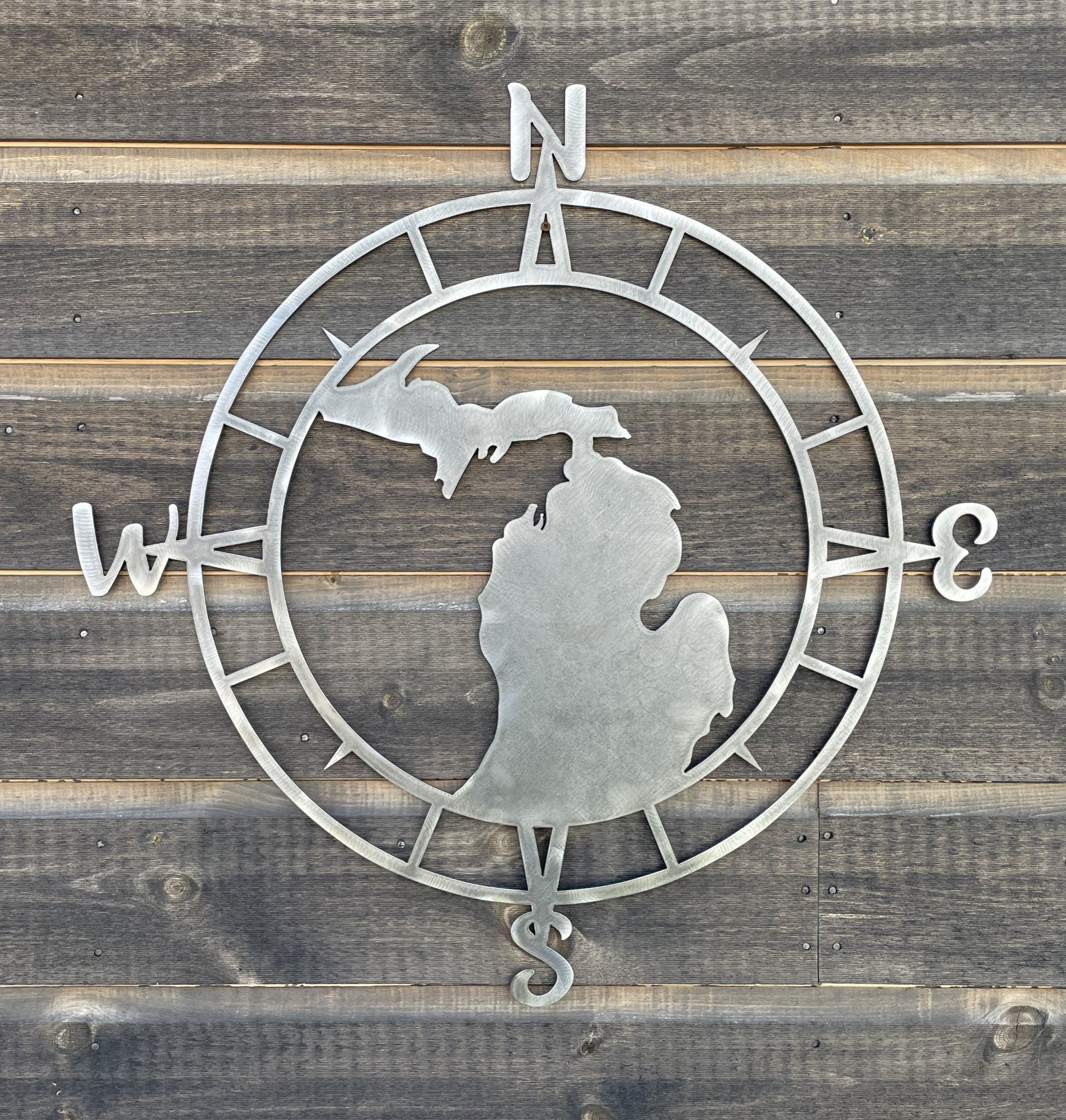 Metal compas wall decor with a silhouette of Michigan in the middle.  Bare metal finish. all states available