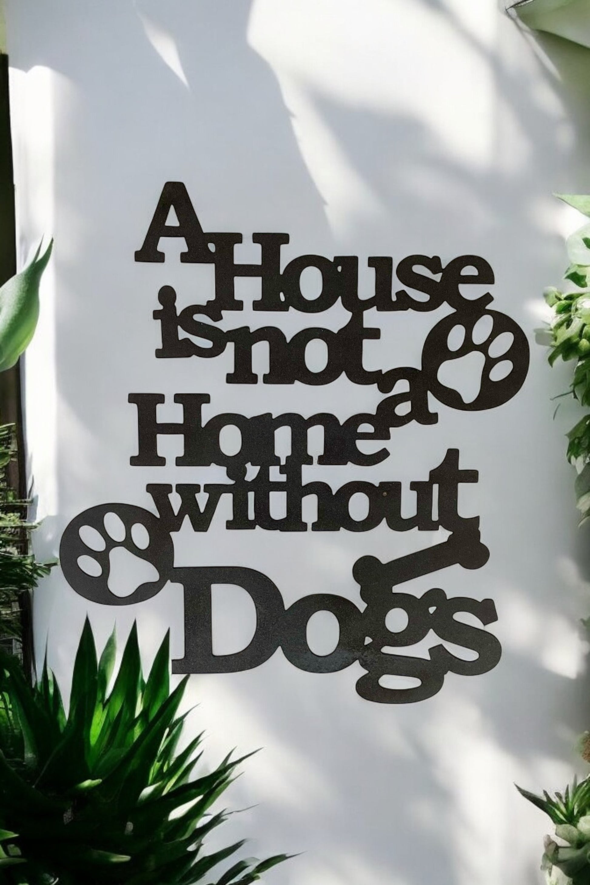 Metal wall sign that reads " A house is not a home without dogs"