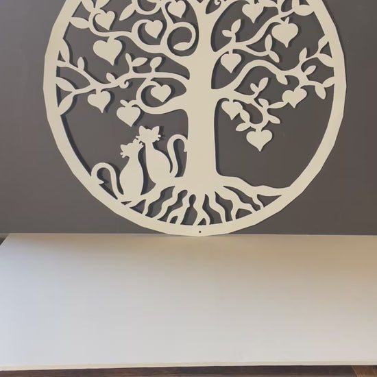 video of white metal art tree with heart shaped leaves and two loving cats